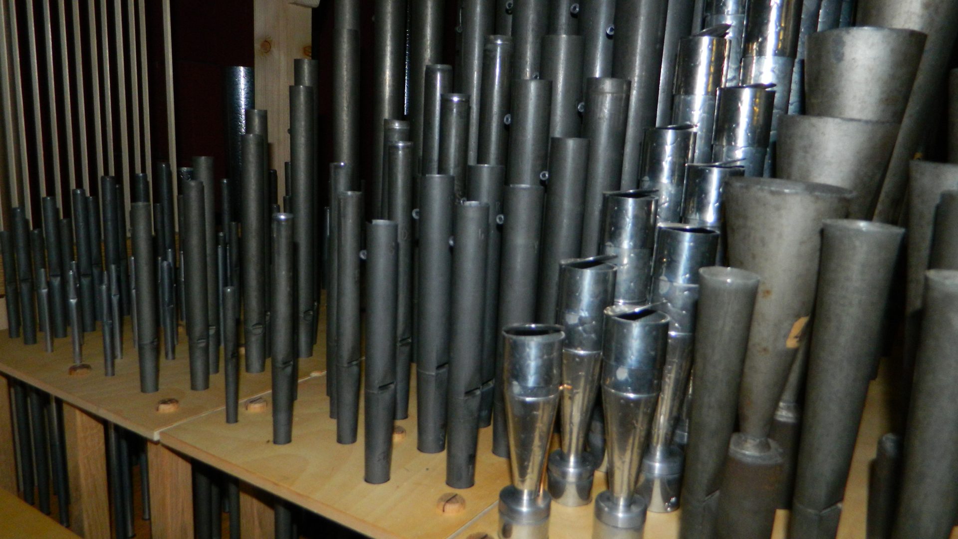 Close interior pipework detail, polished metal pipe mouths catching light