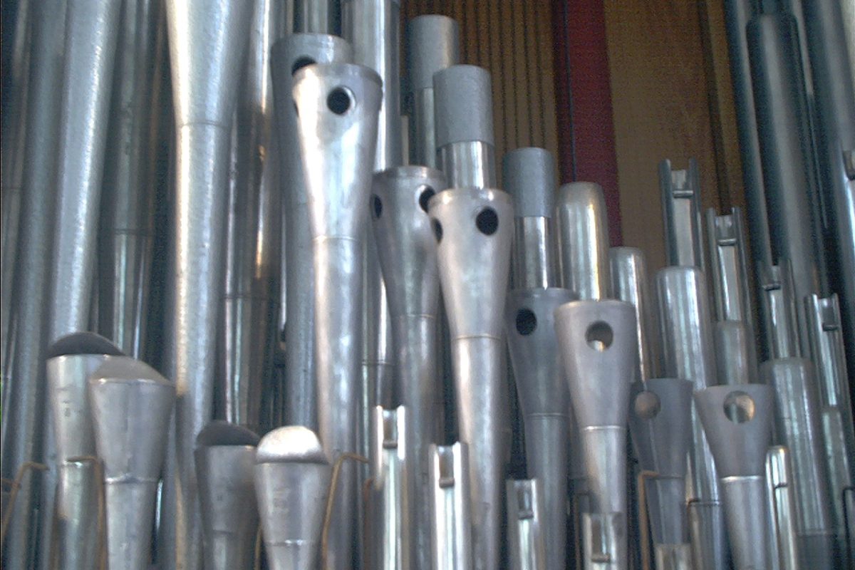 Close detail of gleaming metal organ pipe mouths in a new completed rank