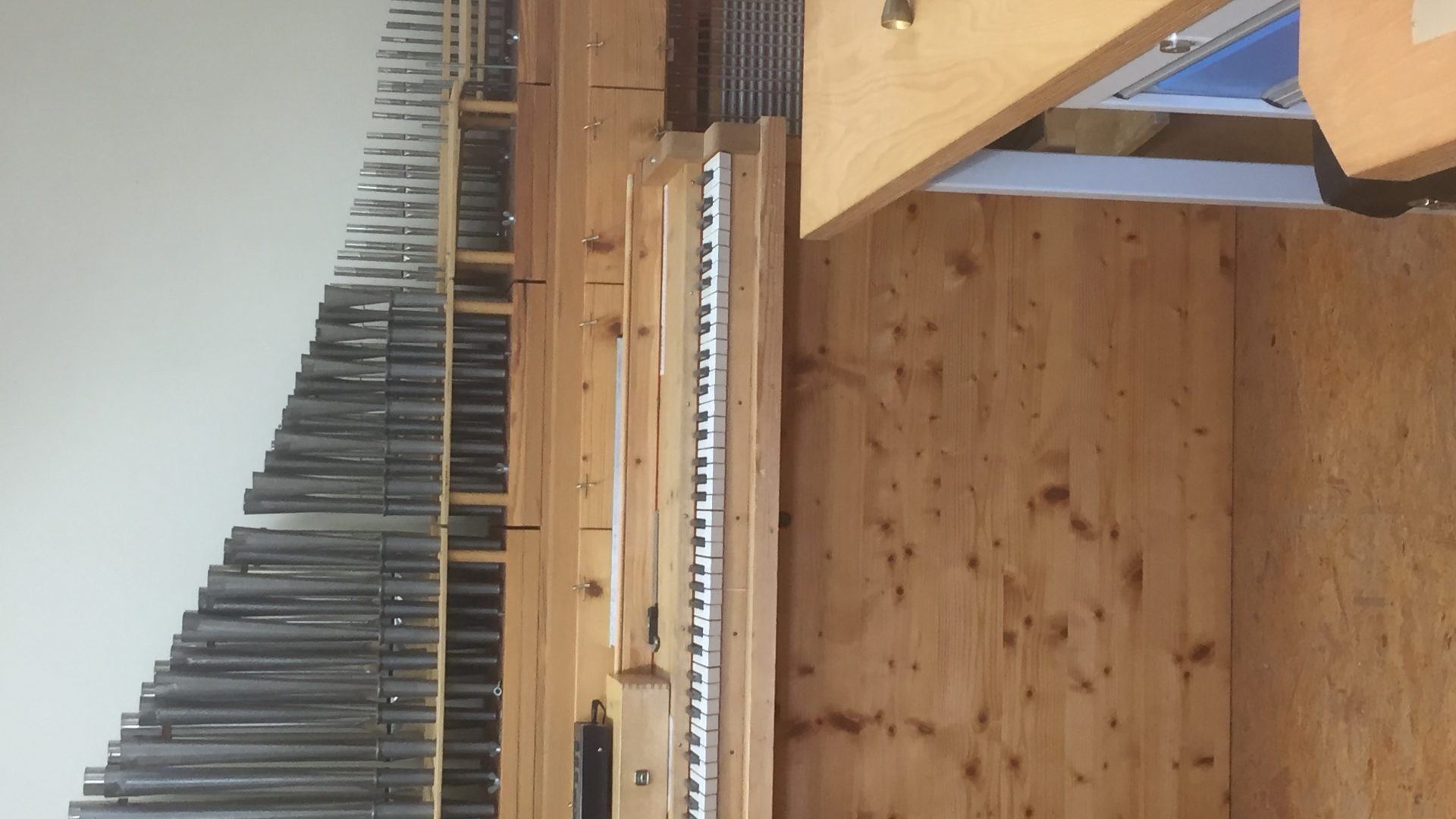 Workshop pipe rack beside a small console under construction on a workbench